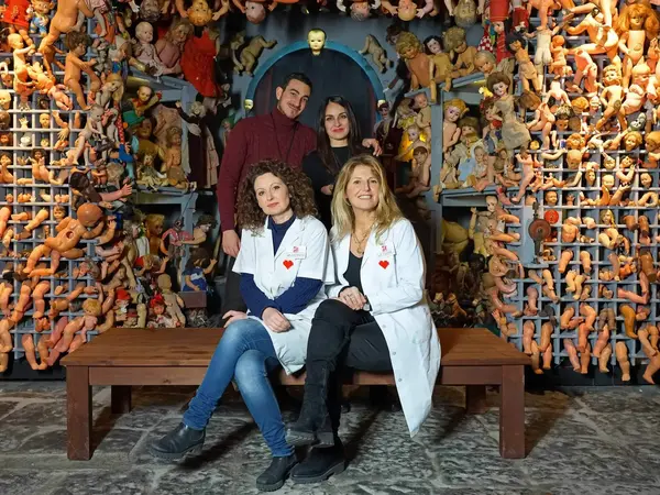 Dolls Hospital Naples - Photo of the team with dolls parts in the background