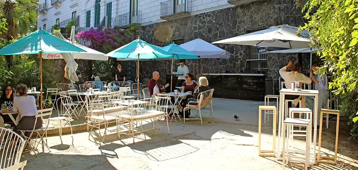 Tables under the umbrellas of the café inside Villa Floridiana